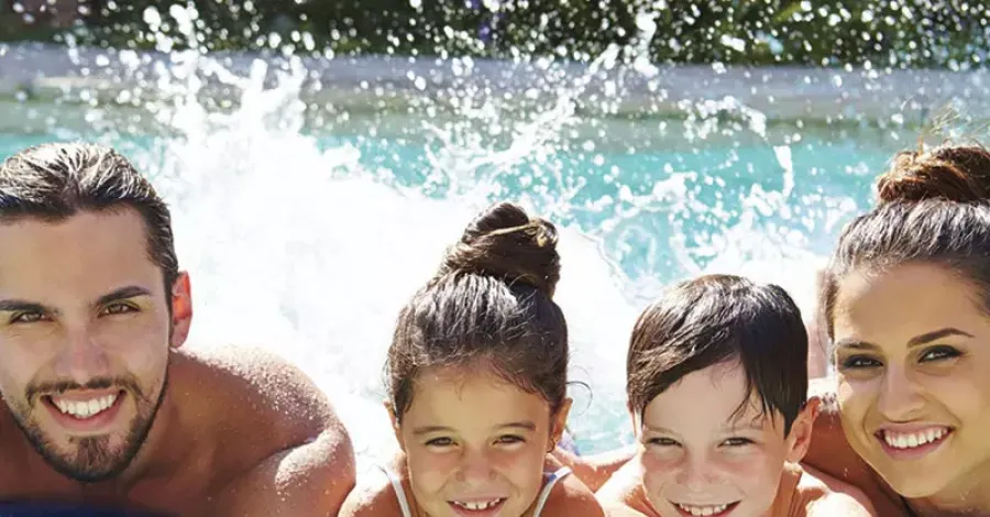 Famiglia felice in piscina su materassino blu.