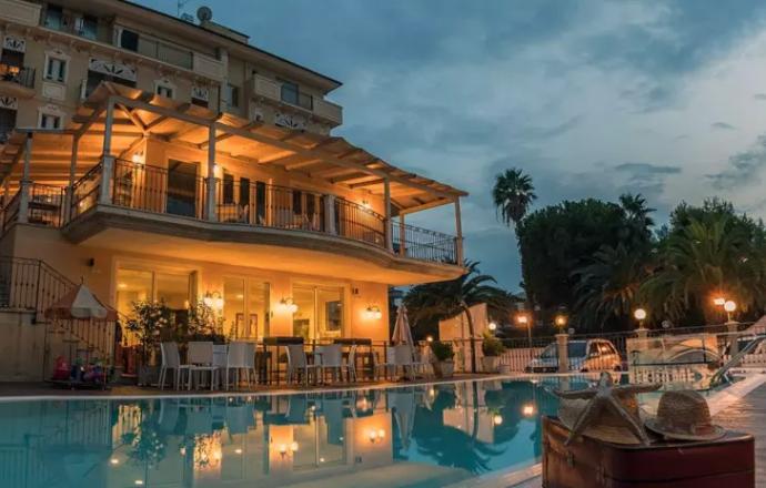 Villa illuminata con piscina al tramonto, atmosfera accogliente e rilassante.